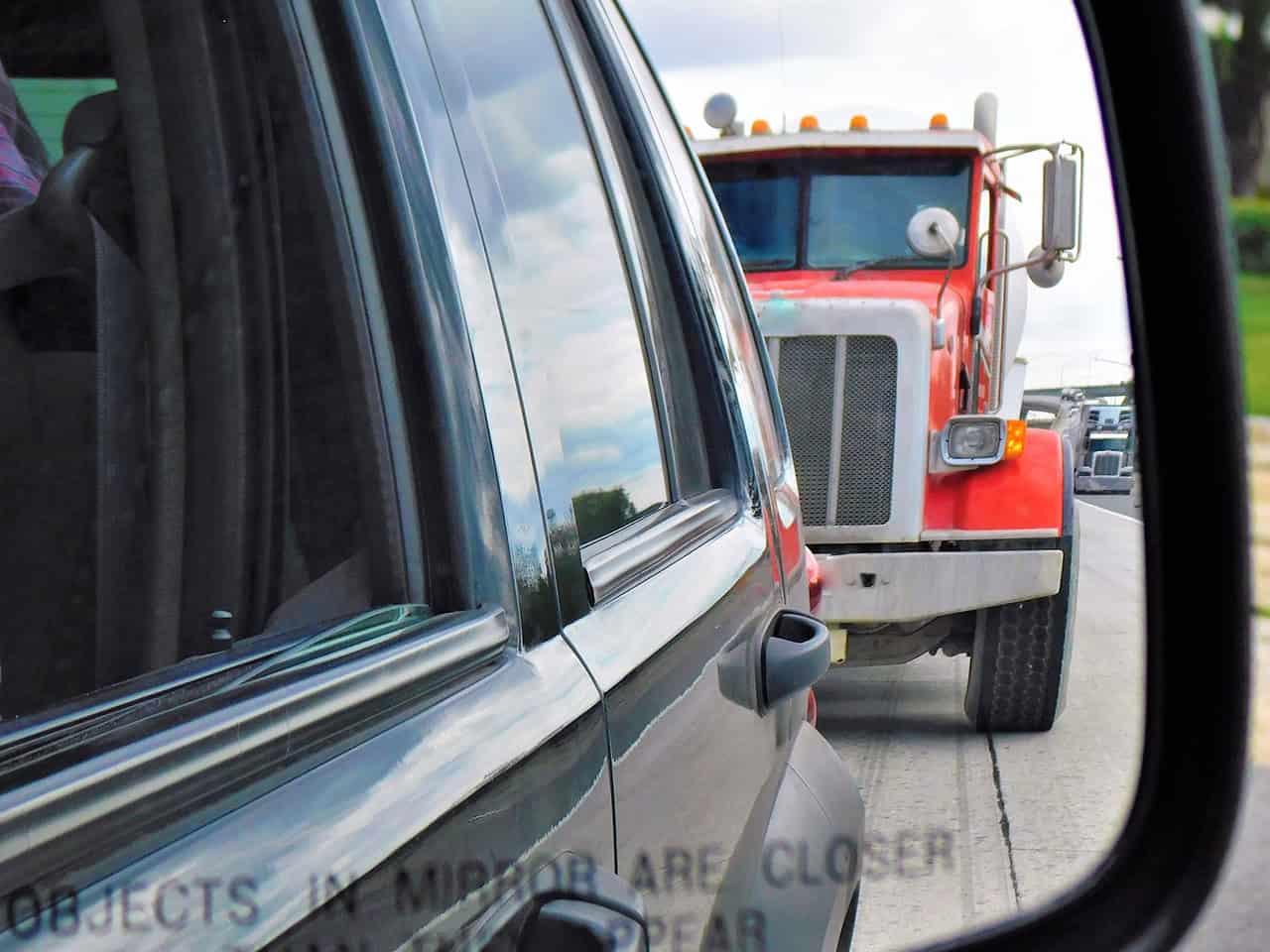 large construction truck behind an mid-sized vehicle