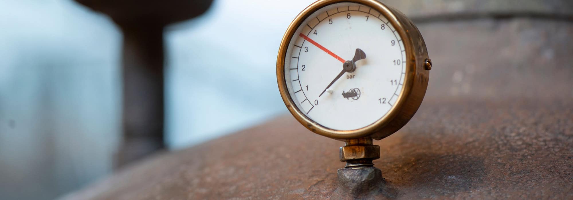 gas gauge on top of a rusty tank