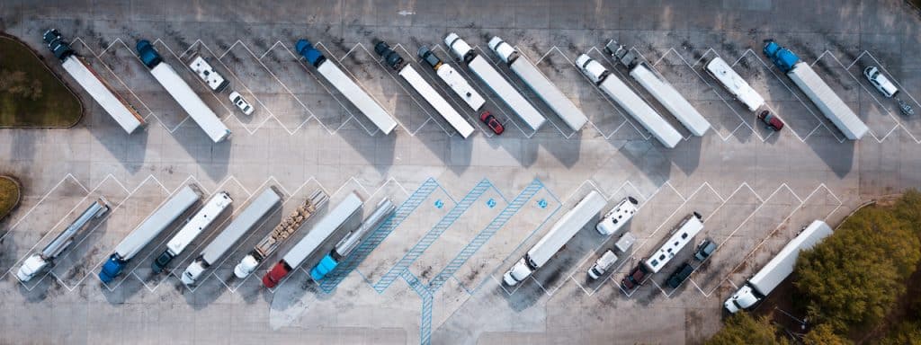 Many trucks in a parking lot of a transport company
