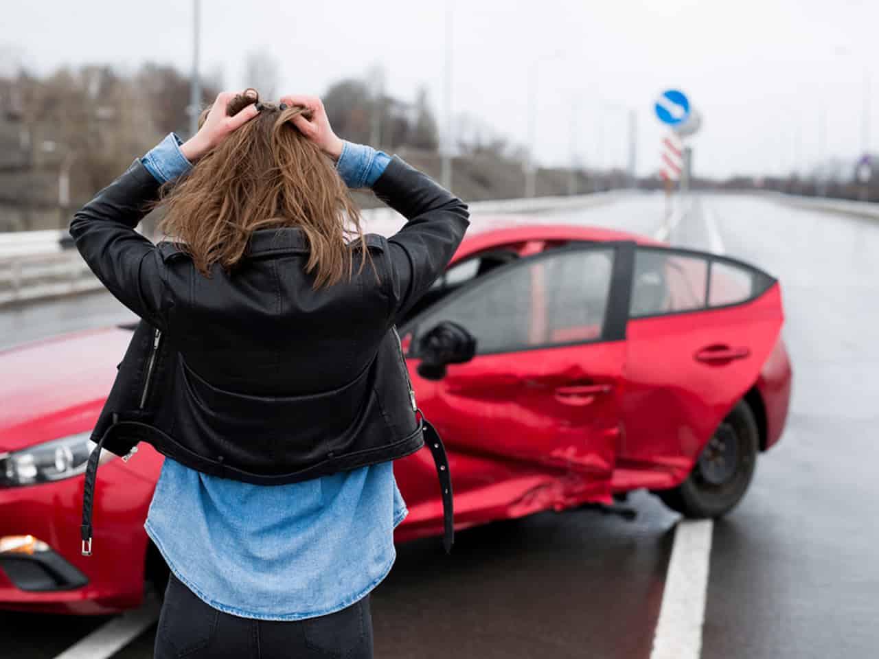 woman holding her hands on her head after a car accident