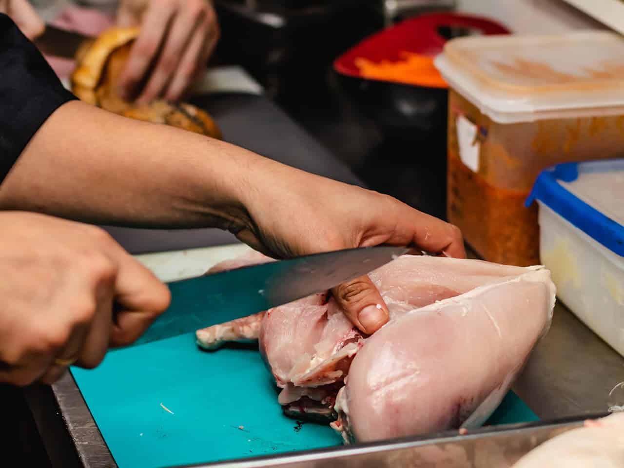Chef cutting raw chicken