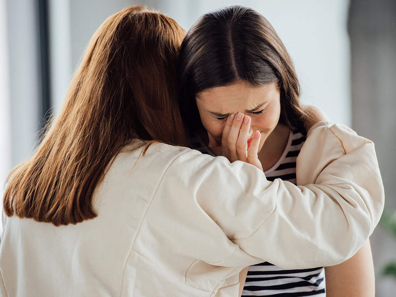 Young girl crying with mother