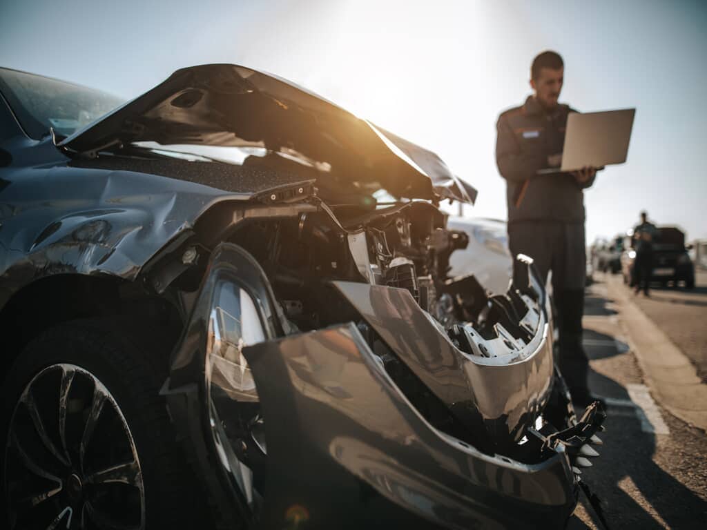 Insurance Agent Evaluating the Damage in a Crashed Car